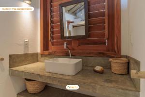 a bathroom with a white sink and a mirror at Vila Oásis no Pontal do Maceió Fortim Vista Mar in Fortim