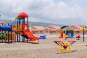 un parque infantil con muchos equipos de diferentes colores. en Comfortable Strategic Lodging Quarters, en Spanish Town