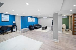 a living room with blue walls and a desk and chairs at Stylish Luxury 3bd home in Downtown Birmingham in Birmingham
