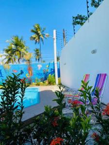 a view of a pool with palm trees and the ocean at Barra Nova Eventos e Lazer in Marechal Deodoro