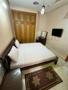 a small bedroom with a bed and a television at B 2 bedroom apartment in Fez
