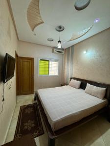 a bedroom with a large bed and a tv at B 2 bedroom apartment in Fez