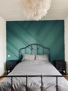 a bedroom with a bed with a green wall at La Villa Hortensia in Jungholtz