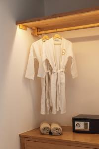 a white robe hanging on a shelf next to a microwave at Birdhouse Private Luxury Suite in Agios Ioannis Mykonos