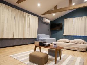 a living room with a bed and a table at HOOD - Vacation STAY 46328v in Amami
