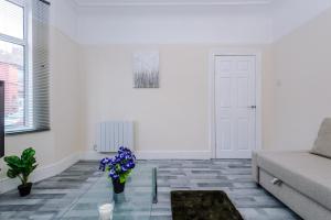 a living room with a couch and flowers on the floor at Beautiful Townhouse Free Parking - Near City and Beach with Fast W-FI in Wallasey