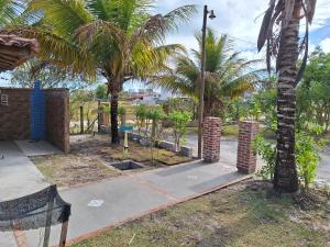 a sidewalk with two palm trees and a street at Casas lindas no paraiso! in Costa Dourada