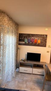 Da Serena في Tarcento: غرفة معيشة مع تلفزيون ونافذة