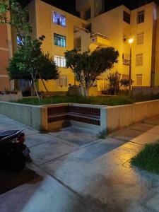 una acera vacía delante de un edificio por la noche en Departamento 4 camas 3 hab, en Tacna