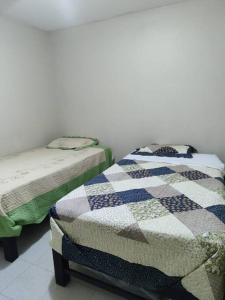 duas camas sentadas uma ao lado da outra num quarto em Departamento 4 camas 3 hab em Tacna