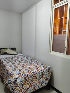 Cama en habitación blanca con ventana en Departamento 4 camas 3 hab en Tacna