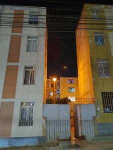 a reflection of a building at night with a street at Departamento 4 camas 3 hab in Tacna