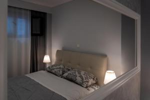 une chambre avec un lit avec deux lampes dessus dans l'établissement Crystal Apartment with free private parking of stayinthess, à Thessalonique