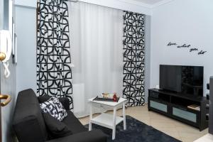 un salon avec un canapé et une télévision dans l'établissement Crystal Apartment with free private parking of stayinthess, à Thessalonique