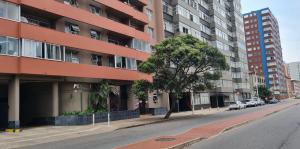 an empty street in front of an apartment building at Penzance by the beach in Durban
