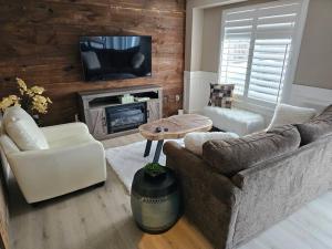 sala de estar con sofá y TV en Cozy Comfort by the Bay, en Midland