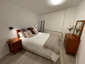 1 dormitorio con cama, tocador y espejo en Apartamento en el centro de Andorra la Vella con parking en Andorra la Vella
