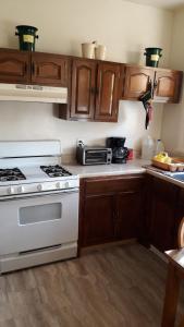 uma cozinha com um fogão branco e armários de madeira em Pleasant Rooming House em Washington