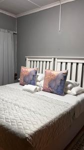 1 cama grande con almohadas en el dormitorio en Lavender Lodge, en Mthatha