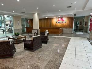 eine Lobby mit einem Wartebereich mit Stühlen und Tischen in der Unterkunft Ninho de Gaivotas 1 - O Resort ! in Rio de Janeiro