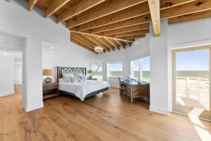 1 dormitorio con 1 cama, escritorio y ventanas en Ocean Therapy Beach House / Ponte Vedra Beach en Ponte Vedra Beach