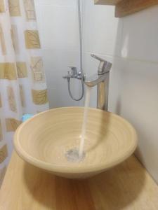 um lavatório com água a sair de uma torneira em Departamentos Mate de Luna em El Bolsón