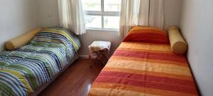 1 dormitorio con 2 camas y ventana en Departamento en Barrio Exclusivo - La Serena, en La Serena