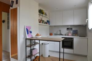 een keuken met witte kasten en een houten aanrecht bij 31 m fully renovated love nest in Boulogne-Billancourt