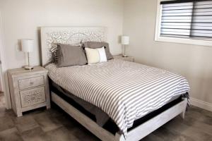 ein Bett mit einer schwarz-weißen gestreiften Bettdecke in einem Schlafzimmer in der Unterkunft Lakeshore Bliss Retreat in Wheatley