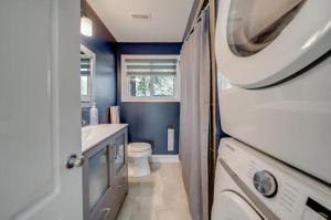 a bathroom with a toilet and a sink and a washing machine at Lakeshore Bliss Retreat in Wheatley