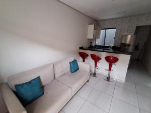 salon z kanapą i 2 czerwonymi stołkami w obiekcie Ingá Hospedagem w mieście Porto Velho