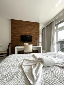 a bedroom with a large bed with a tv on the wall at F1611 Condomínio em Asa Norte in Brasilia