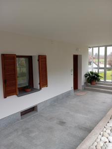 um quarto com paredes e janelas brancas e um pátio em La Casa di Abe - Cuneo em Cuneo