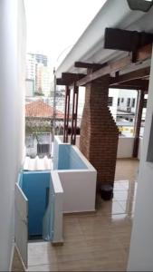 uma varanda com uma banheira azul e branca num edifício em Quarto Disponível em Sobrado em São Paulo