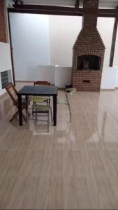 a living room with a table and a brick fireplace at Quarto Disponível em Sobrado in Sao Paulo