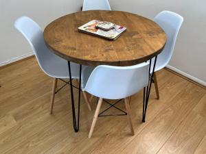 a wooden table with four chairs and a magazine on it at Rural retreat near the Sea in East Portlemouth