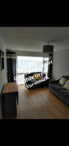 een woonkamer met een bank en een tafel bij No.21 BERMUDA in Hemsby