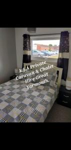 een slaapkamer met een bed met een raam en gordijnen bij No.21 BERMUDA in Hemsby