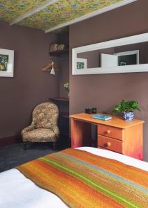een slaapkamer met een bed en een stoel bij Fourteen Providence Place, Calstock, Cornwall, self catering cottage in Calstock