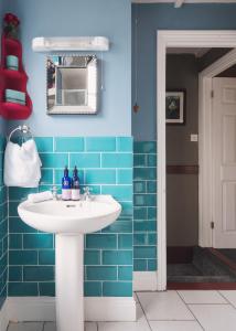 een badkamer met een witte wastafel en blauwe tegels bij Fourteen Providence Place, Calstock, Cornwall, self catering cottage in Calstock