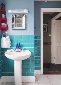 a bathroom with a white sink and blue tiles at Fourteen Providence Place, Calstock, Cornwall, self catering cottage in Calstock