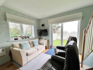 a living room with a couch and a tv at Little Oasis with Sea Views in Stoke Fleming