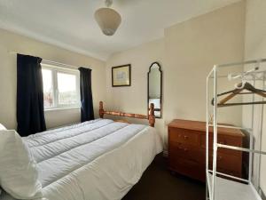 a bedroom with a bed and a window and a dresser at Fantastic central home in Dean