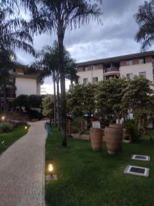 a courtyard with palm trees and a building at L207 Apartamento em resort à beira lago in Brasilia