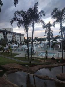 a view of a resort with a pool and palm trees at L207 Apartamento em resort à beira lago in Brasília