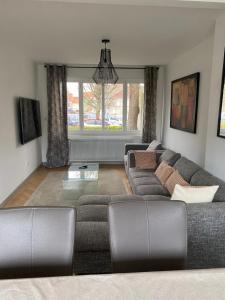 a living room with a couch and a table at Le cottage de Lloyd 4 chambres 2 salles de bain in Bourbourg