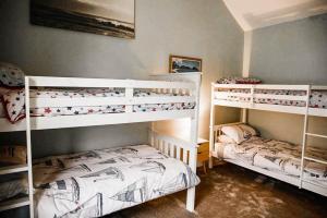 two bunk beds in a small room with at Beautifully decorated bright and cosy cottage in Aveton Gifford