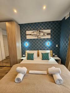 ein Schlafzimmer mit einem Bett mit zwei Handtüchern darauf in der Unterkunft KORZO SUITES SLIEMA I in Sliema