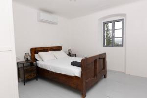 a bedroom with a wooden bed and a window at Villa Floresco in Nerezine