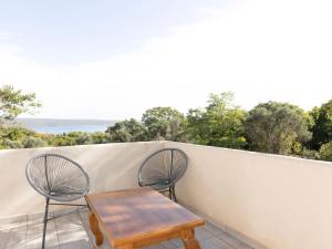 - Balcón con mesa de madera y 2 sillas en Villa Floresco en Nerezine